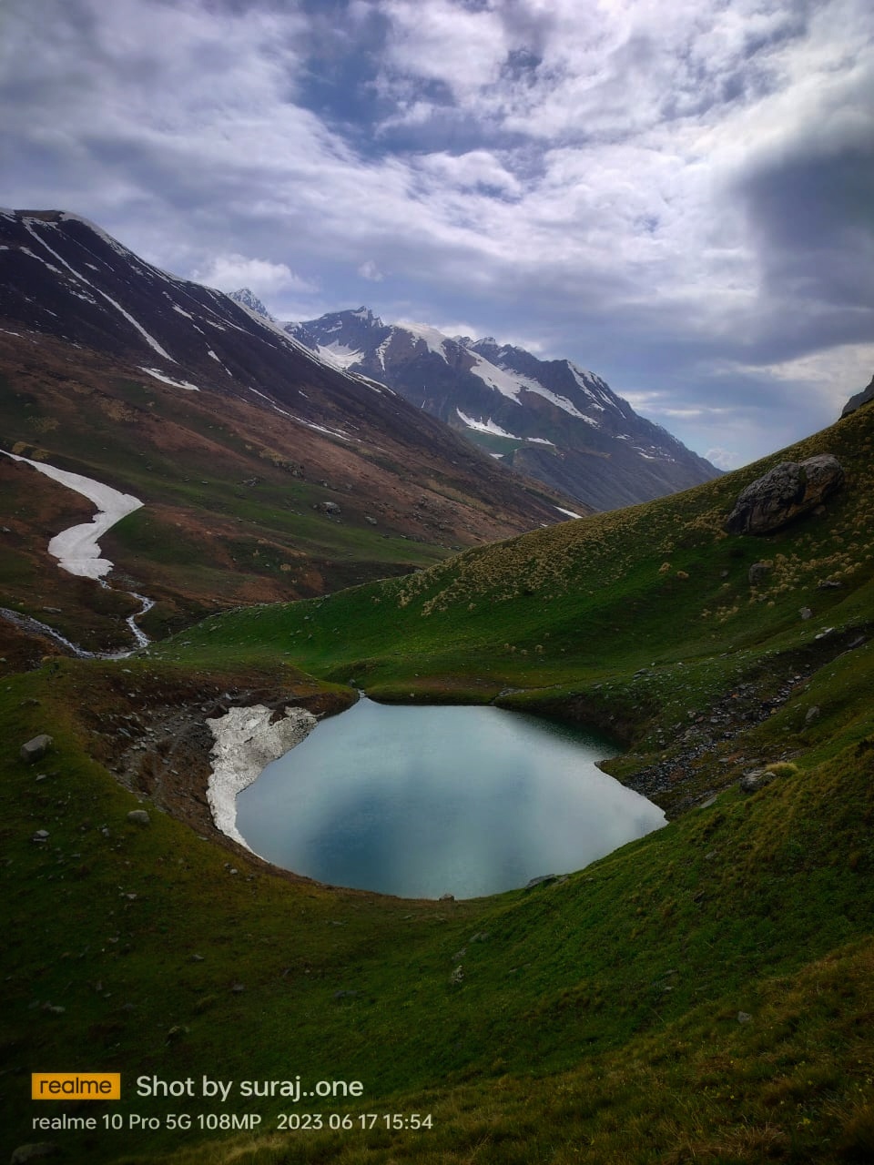 Small alpine lake among high mountain slopes