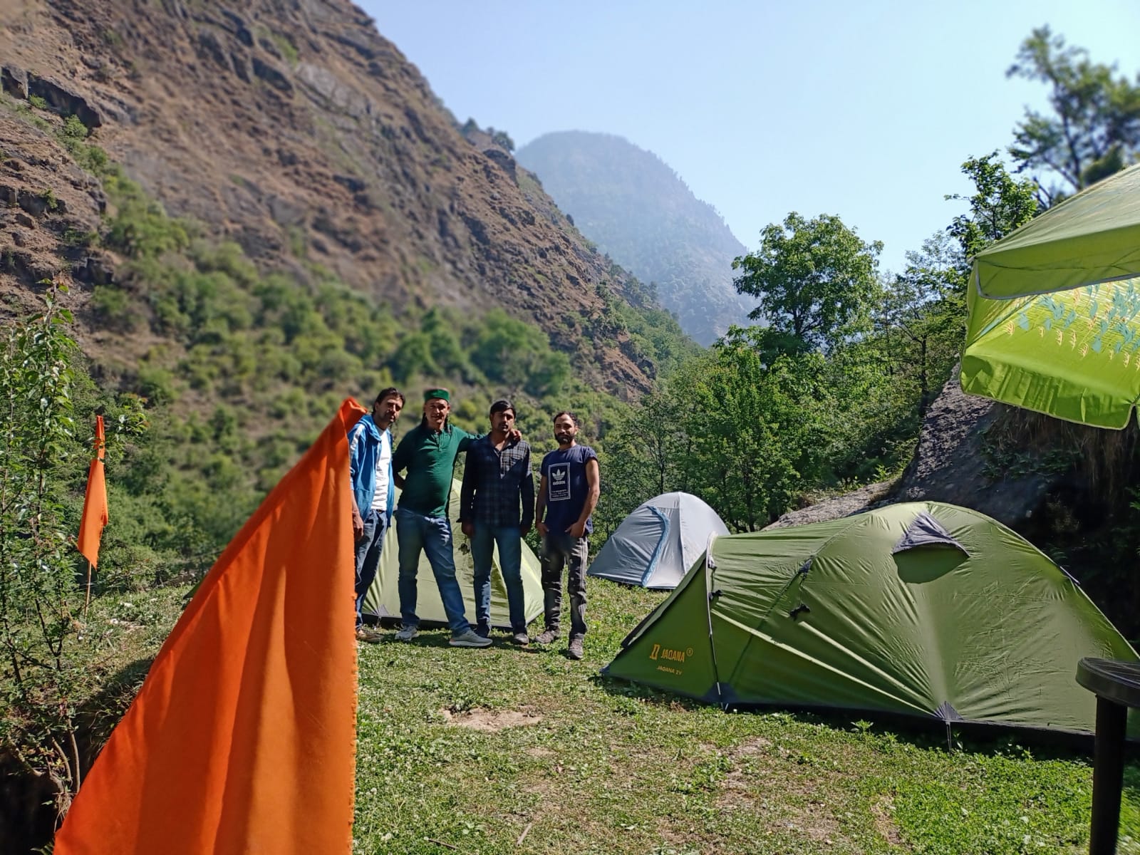 Tents arranged in a green mountain camp