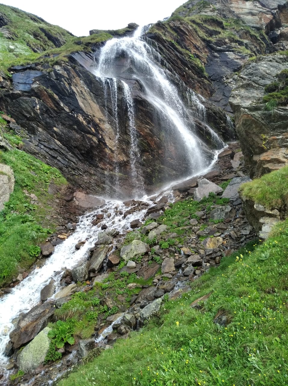 Waterfall descending across a rocky mountain slope
