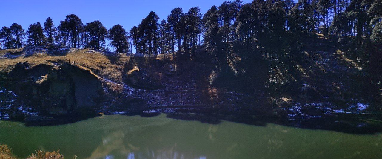 Still water and forest at Serolsar Lake near Jalori Pass